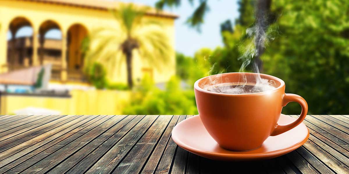 Spanischer Kaffee, Tasse heißer Kaffee vor spanischem Haus
