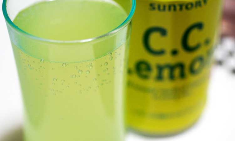 CC Lemon, japanische Zitronenbrause, Glas mit Dose daneben, gelb