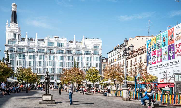 Barrio de las Letras in Madrid, Platz mit weißem Gebäude im Hintergrund, bunter Zaun